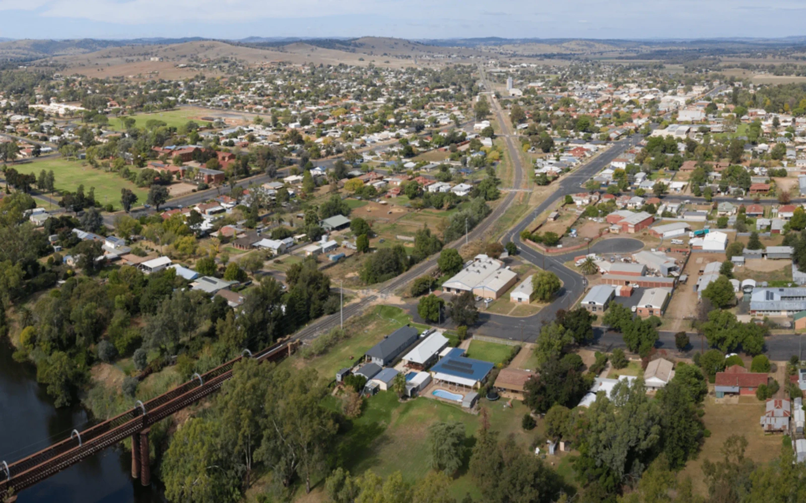 Aerial view of Wellington, New South Wales, showing homes, roads, a river and railway bridge